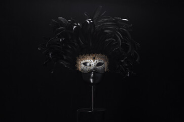theatrical mask with black feathers on a black background