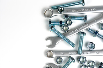 several open-end metal wrenches for working with bolts. Close-up on a white background. Silver metal fixing bolts and nuts. Copy space