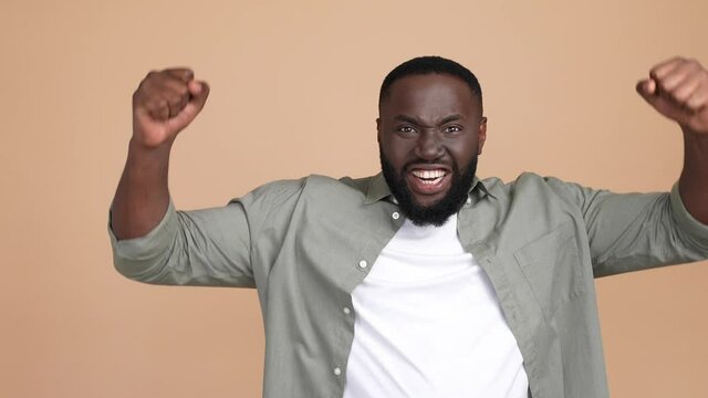 Delighted guy fist up yell yeah aim isolated pastel color background