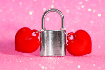 Two hearts locked together with a padlock on pink