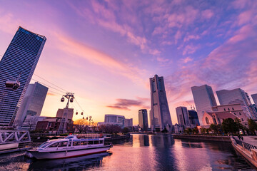 Fototapeta na wymiar 横浜みなとみらいの夕景 / 高層ビル群とロープウェイ・雲を染め上げる夕焼け空のトワイライト
