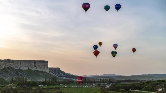 Beautiful rocky landscape of Crimea with colorful hot-air balloons balloons flying on sunset, 4k HDR Time Lapse footage 