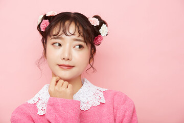 ピンク背景の若い女性のガーリーなポートレート