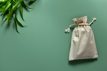 Cotton reusable bag bamboo on green background. Eco-friendly zero waste concept.