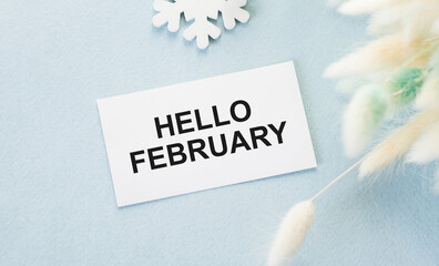 Hello February text on a card on a blue background