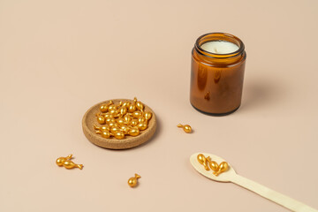A face serum or oil in golden capsules lying on a beige background