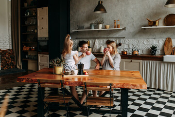 A happy family with one child having breakfast laughing sitting at the dining table in a loft-style...