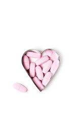 Pink organic vitamin tablets in heart-shaped form on white background