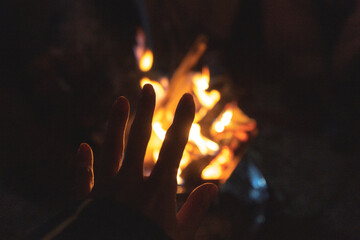 焚火の炎で手を温めるシルエット