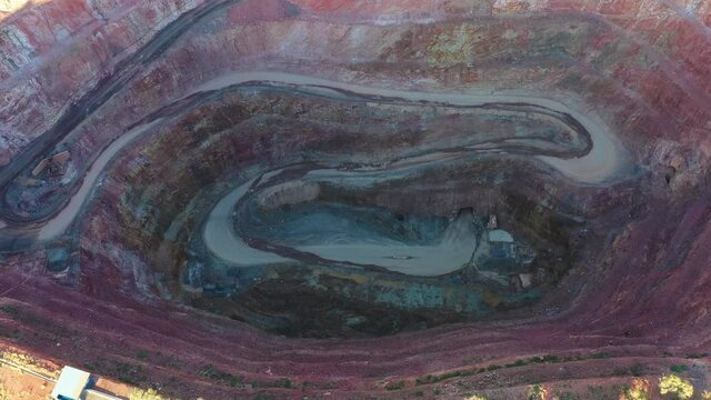 Deep open pit mine of copper ore in Cobar town of outback &ndash; aerial down 4k.
