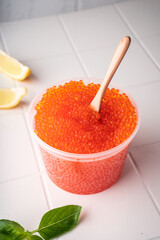 Natural red caviar from trout and salmon. A pure product, a delicacy. On a white background in a beautiful presentation
