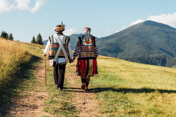 Beauty wedding couple in traditional clothes over mountains background. Ukrainian folklore wedding, culture, ethical traditions, concept.
 - obrazy, fototapety, plakaty