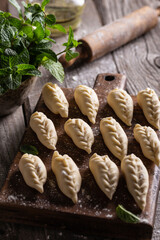 Uncooked culurgiones on a wooden board