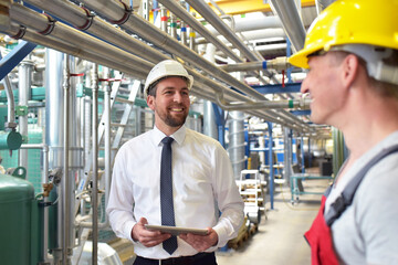 businessman and worker meeting in a factory - maintenance and repair of the industrial plant