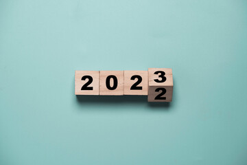 Flipping of 2022 to 2023 on wooden block cube for preparation new year change and start new...