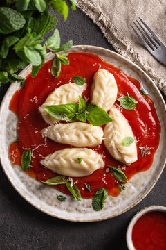 traditional Italian food culurgiones with tomato sauce and basil