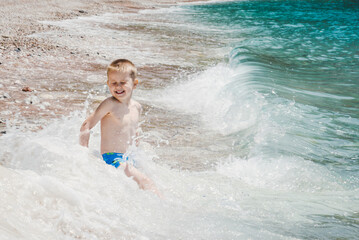 Excited Boy Having Fun at Beach in Waves