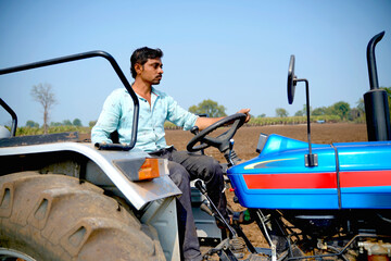 Indian farmer working with tractor in agriculture field.