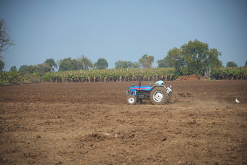 Obraz premium Indian farmer working with tractor in agriculture field.