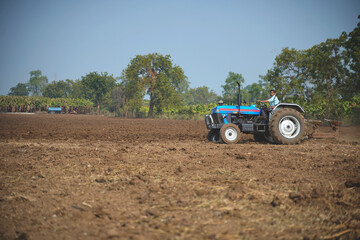 Obraz premium Indian farmer working with tractor in agriculture field.