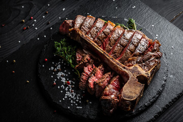 Dry Aged Barbecue Porterhouse Steak T-bone beef steak sliced with large fillet piece with herbs and salt. American meat restaurant