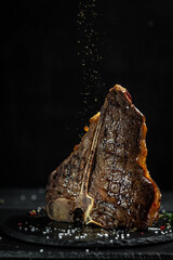 Dry Aged Barbecue Porterhouse Steak T-bone beef steak sliced with large fillet piece with herbs and...
