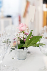 A vertical shot of some flowers in a pot on a table prepared for the wedding