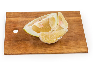 Slices of ripe pomelo on a wooden cutting board