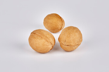 Three walnuts on a gray background in the center