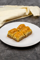 Walnut baklava on a dark background. Traditional Turkish cuisine delicacies. Close-up.
