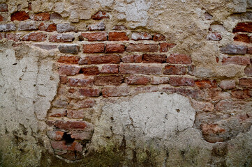 The Old Cracked Wall of a concrete building. A part of the red brick wall was abandoned.