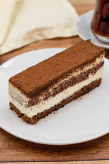 portion tiramisu cake on wooden background. Traditional world cuisine delicacies. Close-up.