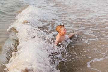 Laughing Boy Having Fun at Beach in Waves