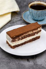 portion tiramisu cake on dark background. Traditional world cuisine delicacies. Close-up.
