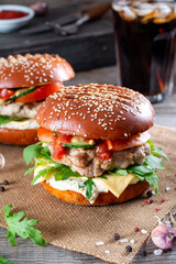 Burgers with cutlet, tomato, arugula, cucumber, onion and cheese. American cuisine. Fast food.