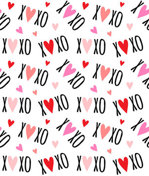 Vector seamless pattern of Valentine xoxo text and red hearts isolated on white background