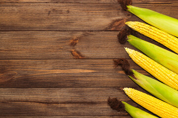 Sweet yellow corn lies on a wooden table.