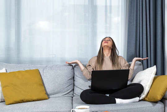 Young Student Or Business Woman Sitting At Home Covering Her Ears With Hands Because She Cant Study Or Work On Her Laptop Computer From Loud Noise Coming From Apartment Above. 