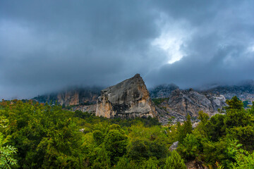 Fototapeta premium Stony slopes of mountain in dense fog.