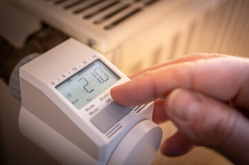 Modernes digitales Heizungsthermostat an Heizung wird eingestellt