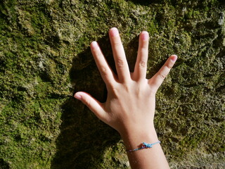 hand of a child on a rock wall