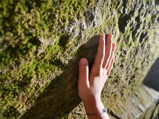 hand of a child on a rock wall
