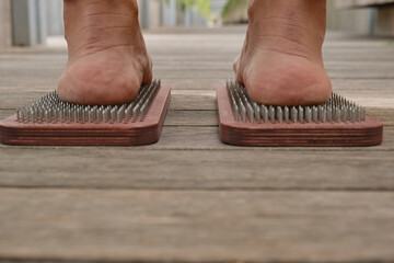 The practice of self-knowledge in the park. A woman with a pedicure stands on sharp nails. Female...