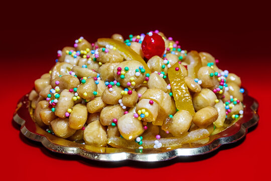 Struffoli, typical Neapolitan pastry consisting of many small balls of dough fried in oil and wrapped in warm honey. Decorated with colored sprinkles.