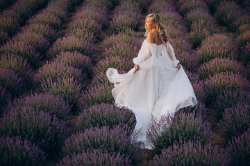 Beautiful woman in wedding dress in lavender field