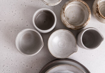 Handmade ceramic tableware, empty craft ceramic on a light background. Clay plates and cups