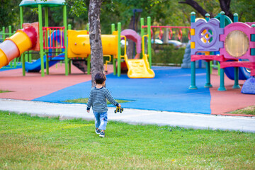 Happy asian boy play truck toy in outdoor playground park