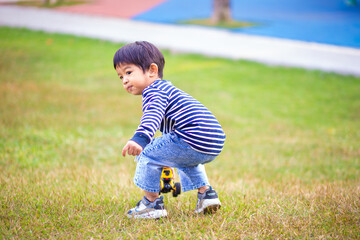 Happy asian boy play truck toy in outdoor playground park