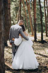 Young wedding couple having photoshoot in forest
