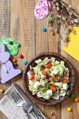 Holiday food, easter salad. Salad with chinese cabbage, feta, cherry tomatoes and canned tuna and vinegar dressing on a festive table. Top view flat lay. Copy space.